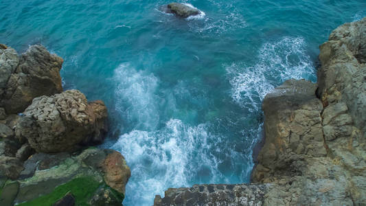 上部俯瞰大海与海浪打破和发泡岩石的海滩上