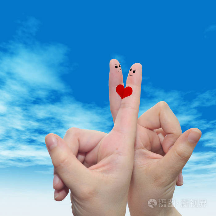 概念或概念人类或女性的双手用两个手指涂着红色的心在云蓝色的天空