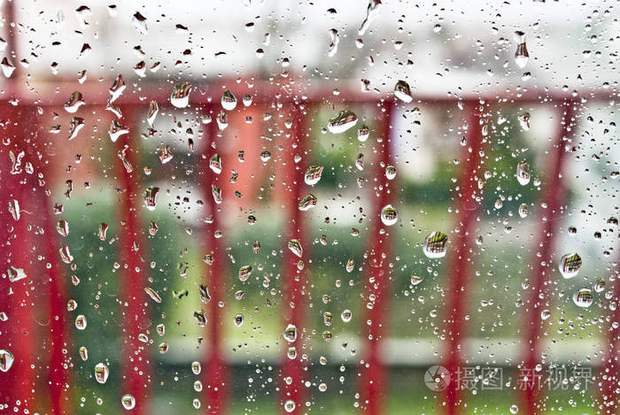 雨中的窗户玻璃被雨淋湿了,玻璃上的水滴