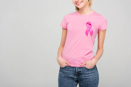 微笑的年轻女子，穿着粉红色T恤，戴着灰色的乳腺癌意识丝带