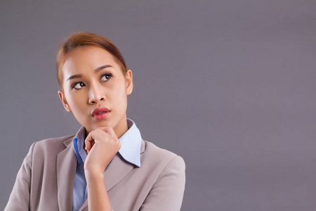  portrait of asian business woman thinks, plans, finds good idea