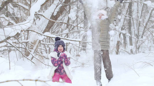 两个小女孩在冬天的森林里玩雪