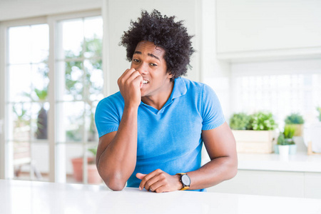 美国黑人男子在家看着压力和紧张，双手咬嘴指甲。焦虑问题。