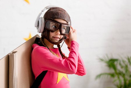 携带头盔和护目镜的儿童听耳机音乐
