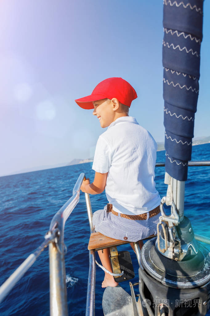 船上的小男孩在夏天乘坐游艇出海巡航.冒险旅行,家庭度假游艇与孩子
