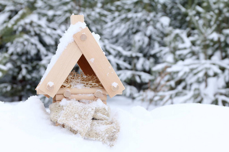 冬天和寒冷的雪天气里带着温暖围巾的原木屋的模型。 加热系统的概念和节能技术。