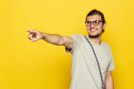 时尚的不修边幅的男人, 穿着 t恤的人在黄色墙上的复制空间里表现出