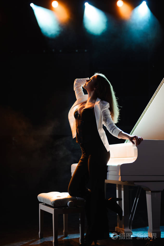 舞台上有白色钢琴的女人
