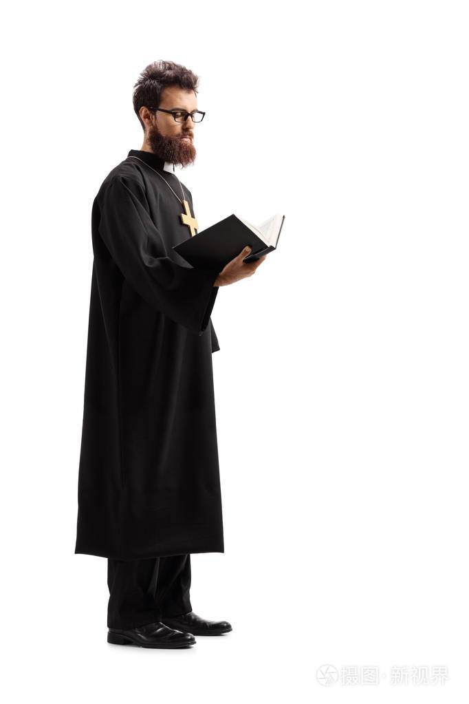 一个牧师站着,从白色背景上隔离的圣经中阅读的完整镜头
