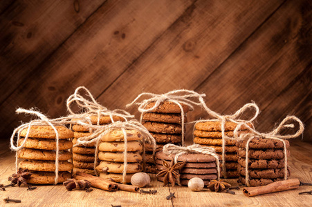 各种脆饼, 燕麦饼干, 巧克力片饼干和香料在黑暗的乡村木桌上
