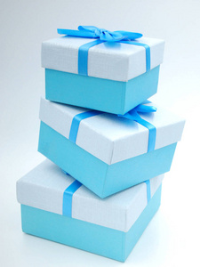 三个蓝色礼品盒，蓝色丝带和蓝色蝴蝶结
