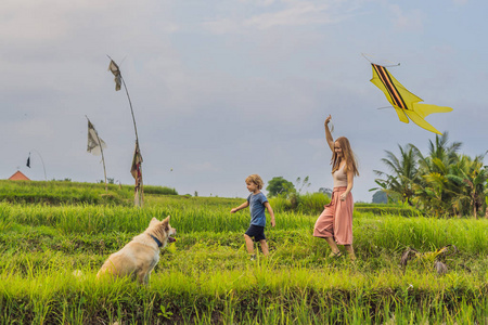 妈妈和儿子在印度尼西亚乌布巴利岛的稻田里放风筝。