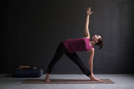 女孩站在 utthita trikonasana, 延长三角形姿势