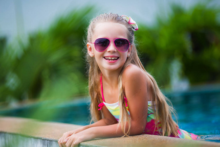 可爱开朗的微笑女孩在游泳池里度假。 夏季