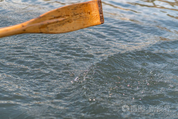 用于划船的木桨特写镜头.在阳光明媚的日子里, 湖面在水中划船