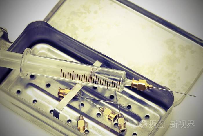 玻璃材料中的非常旧的注射器,以及金属外壳和更多的奈德的复古调色