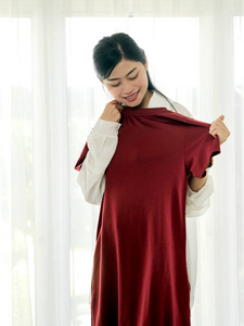 快乐的亚洲女人展示她的新衣服刚刚从网上送货服务现代生活方式的概念。