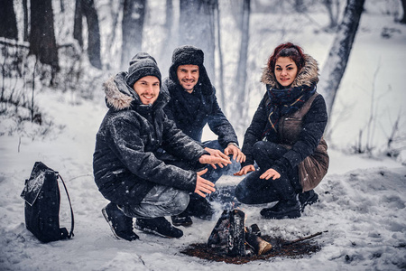 一群快乐的朋友在雪堆的森林里进行了露营