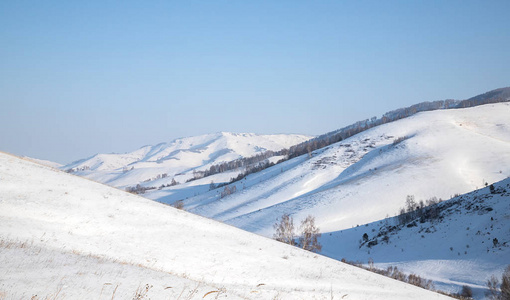 美丽的，冬季的山景背景清澈，蓝天，树木和走在阿尔泰地区的道路上