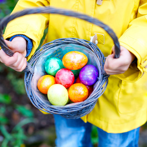用五颜六色的复活节彩蛋在篮子里的小孩子的双手关闭。孩子在做蛋狩猎儿童在国内花园寻找和寻找五颜六色的鸡蛋。老基督徒和 cathol