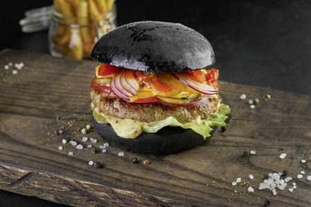 黑色背景的乡村木板上的黑色汉堡