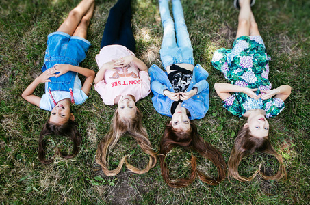 4个女孩正躺在草地上积极向上的女学生女朋友