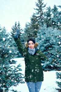 美丽的女人在冬天，森林，绿杉树和雪。