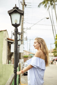 一位穿着蓝色裙子的年轻美女，穿着路灯