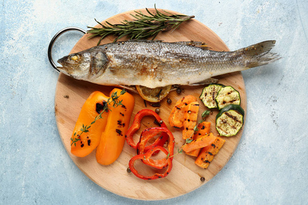 木制木板，有美味的煮熟的海鸟鱼和蔬菜