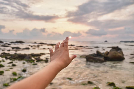 女孩伸手到云端.女孩把她的手拉到海里照片