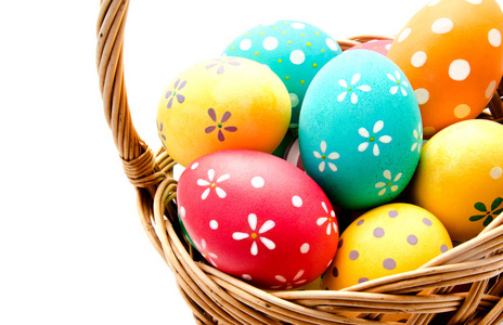 完美的彩色手工复活节彩蛋在篮子里隔离在白色上