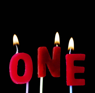 一个在红色生日蜡烛在黑色背景下的拼写