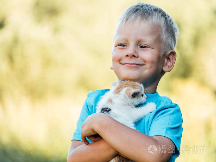 乡下的小男孩抱着他可爱的毛茸茸的小猫。 宠物和生活方式概念