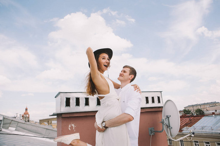 在屋顶上散步,拥抱和笑着从城市屋顶看到积极和真诚的爱的情绪照片