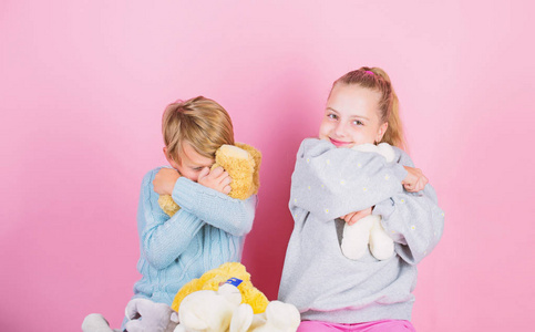 熊玩具收藏。泰迪熊帮助孩子们处理情绪和限制压力。兄弟姐妹顽皮地抱着泰迪熊毛绒玩具。男孩和女孩玩软玩具泰迪熊粉红色的背景