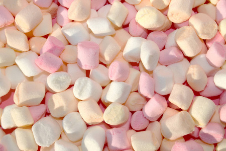 在粉红色的背景与复制空间的棉花糖。平面或顶部视图。背景或纹理的五颜六色的迷你棉花糖。冬季食品背景概念