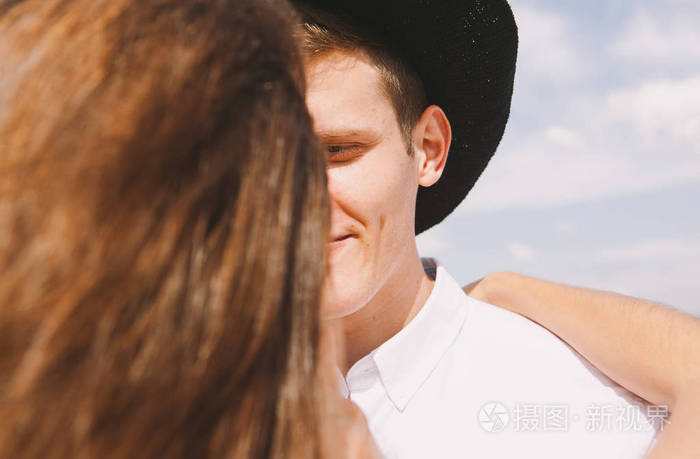 一对相爱的夫妇在房子的屋顶上 一个穿着白色连衣裙和帽子的女孩和一个从城市屋顶俯瞰风景的男人照片 正版商用图片192jkz 摄图新视界