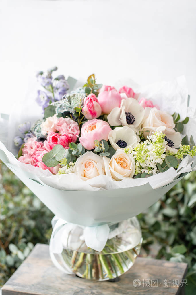 在木桌上的花瓶里, 美丽的新鲜切花花束.花商在花店的作品.