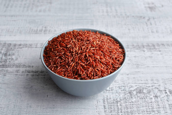 碗与未煮熟的红色米在木背景