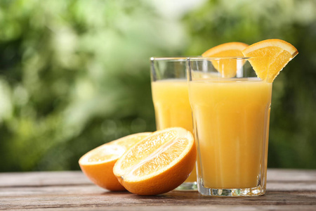 木桌上的橙汁和新鲜水果杯。 文本空间