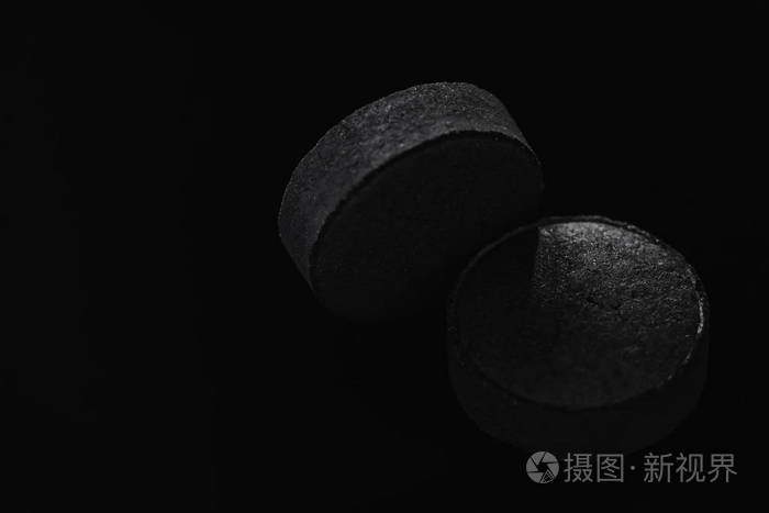 黑色药丸片药孤立在黑色背景上极端接近宏观