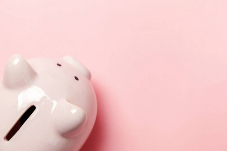 储蓄投资预算财富退休金融货币银行理念。 粉红色的储蓄罐隔离在粉红色的粉彩色的时髦背景上。 平躺顶视复印空间