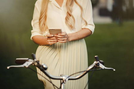 漂亮女孩的肖像与老式复古自行车使用智能手机。