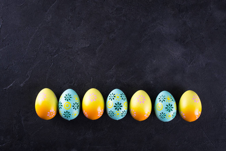 复活节假期背景与鸡蛋。 多彩彩绘鸡蛋排在一排