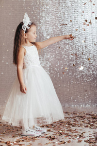小女孩在公主礼服上五彩纸屑背景