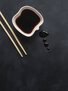 黑色背景上的筷子和酱油