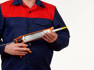 穿着工作服的人拿着白色背景的工具钉子照片