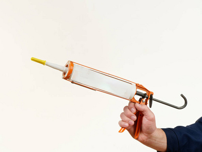 穿着工作服的人拿着白色背景的工具钉子照片