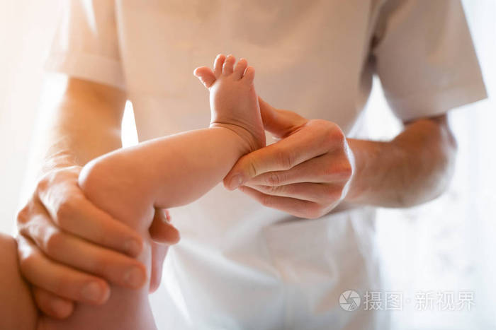 图片来自新生婴儿和男性按摩师手上方