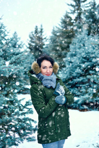 美丽的女人在冬天，森林，绿杉树和雪。